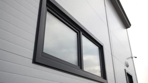 Warehouse wall with window reflecting sky and door with CCTV Stock Footage 291330360