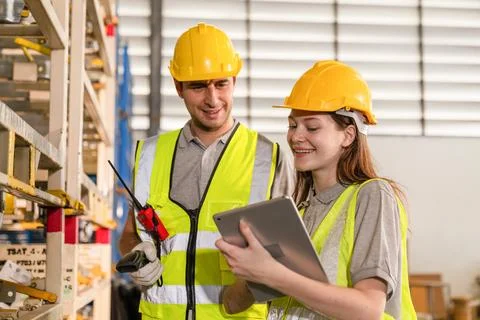 Warehouse worker and managers check stock. Stock Photos