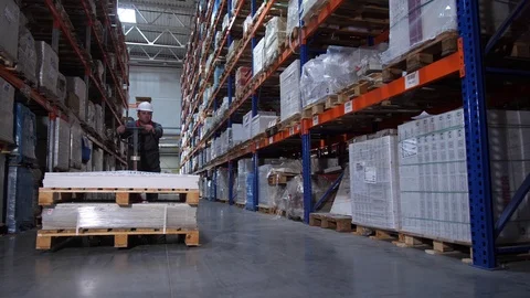 A warehouse worker carries huge boxes on a manual forklift. 4K Slow Mo Stock-Footage 111767496
