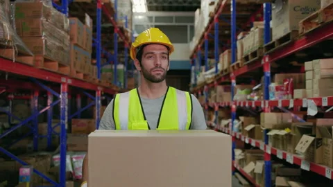 Warehouse worker carrying boxes of goods to be sorted on the shelves. Stock Footage 223384518
