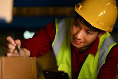 Warehouse worker checking goods and supplies on shelves in large warehouse Stock Photos
