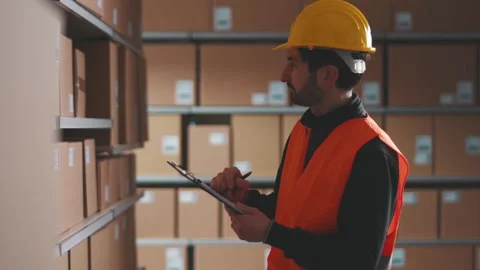 Warehouse worker checking orders and doing inventory control Stock Footage 266504446