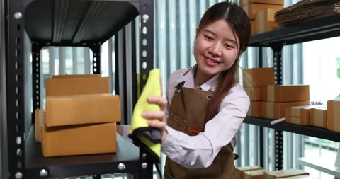 Warehouse worker cleaning storage shelves and organizing shipping boxes 库存影片 343532978