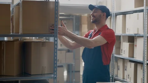 Warehouse Worker Collects Cardboard Boxes and Parcels of the Shelf and Puts 库存影片 96142946