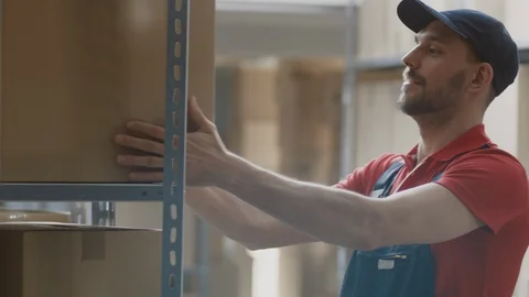 Warehouse Worker Collects Order by Taking Cardboard Boxes and Parcels of Shelf Stockbeeldmateriaal 96142835
