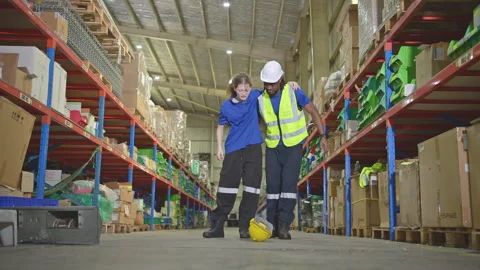 A warehouse worker consoles and helps a female worker Stock Footage 254405723