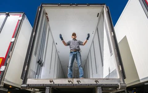 Warehouse Worker Directing Semi Trailers Under Bright Blue Sky Stock Photos