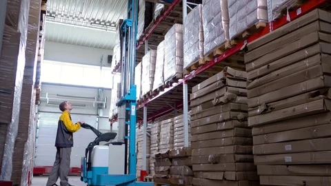 Warehouse worker driver in uniform delivery and loading cardboxes by forklift Stock Footage 114758761