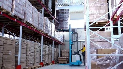 Warehouse worker driver in uniform loading cardboard boxes by forklift stacker Stock Footage 115017121