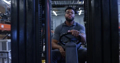 Warehouse worker driving a forklift in warehouse Video stock 116369980