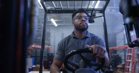 Warehouse worker driving a forklift in warehouse Stock Footage 116370481
