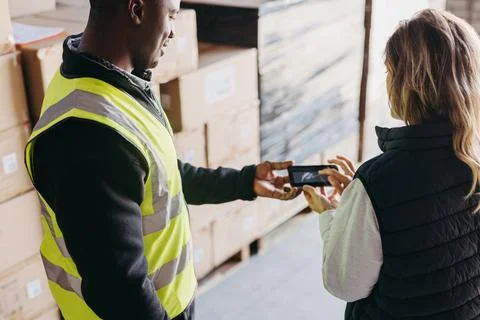 Warehouse worker e-signing a dock receipt after receiving a delivery Stock Photos