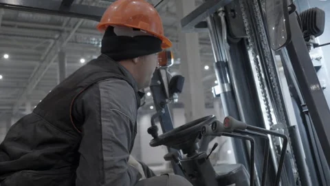 Warehouse Worker Efficiently Operating a Forklift within a Busy Industrial Work Stock Footage 291611301