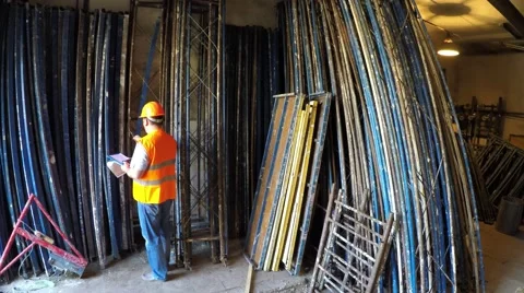 Warehouse worker finds elements of scaffolding. Video stock 51547689