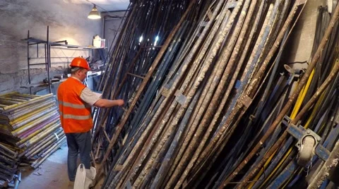 Warehouse worker finds elements of scaffolding. Video stock 51547751