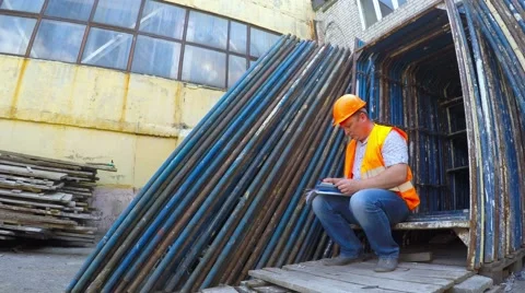 Warehouse worker finds elements of scaffolding. Stockbeeldmateriaal 51547917