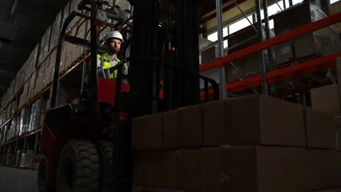 Warehouse worker on forklift moving goods in boxes Video stock 161950796