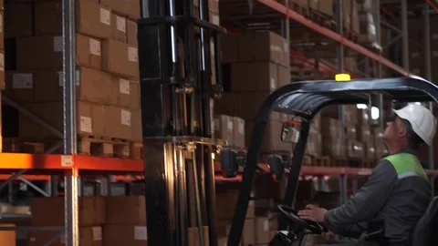 Warehouse worker on forklift placing load on shelf 스톡 동영상 161955272