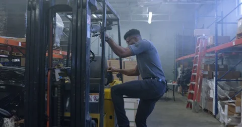Warehouse worker getting ready to use a forklift in warehouse Stock Footage 116366619