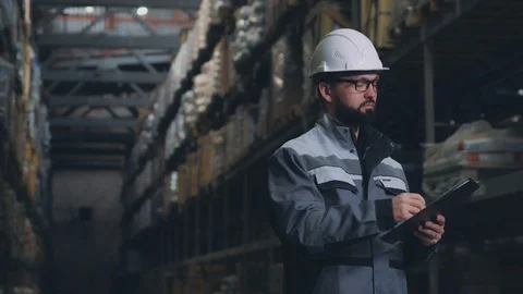 The warehouse worker in gray uniform carries out an audit. Video stock 88391963