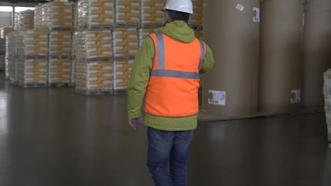 Warehouse worker in hard hat using mobile phone Stock Footage 101233626