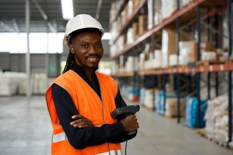 Warehouse worker holding barcode scanner smiling at logistics center Stock Photos