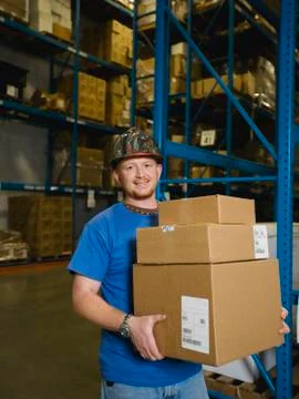 Warehouse worker holding stack of boxes Stock Photos
