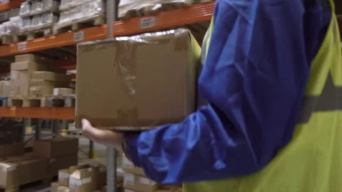 Warehouse worker lays box on rack Stock Footage 75966150