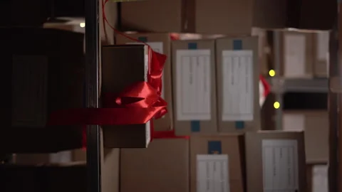 Warehouse worker looking for a parcel on the shelves full of boxes with things Stock Footage 248275516