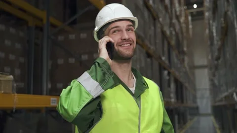 Warehouse worker man talking on the phone. employee smiles and discusses on Stock Footage 148149728