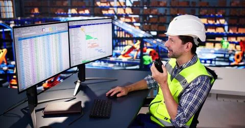 Warehouse Worker Manager Using Computer And Walkie-Talkie Stock Photos