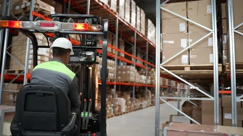 Warehouse worker moving goods riding forklift Video stock 161946703
