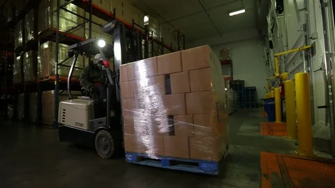 Warehouse worker. Moving palette of boxes with forklift. wide A Stock Footage 101976319