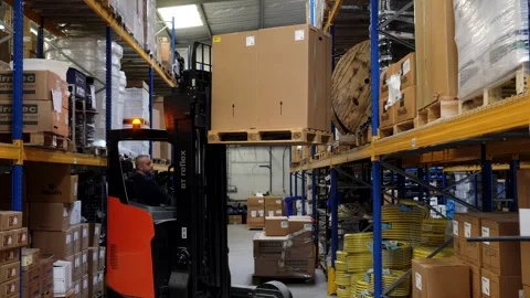 Warehouse Worker Operating Forklift Lifting Large Boxes in Irrigation Supply Stock Footage 341919163