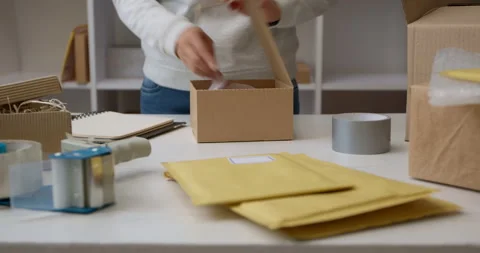The warehouse worker packs the goods in a box for delivery by courier service. Stock Footage 166522636