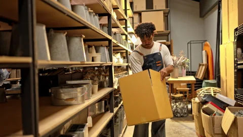 Warehouse worker picking products and placing them into a box for delivery Stock-Footage 339641794