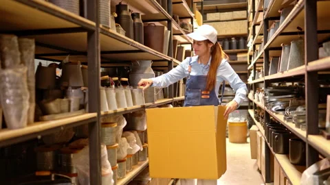 Warehouse worker picking products and placing them into a box Stock Footage 339642442