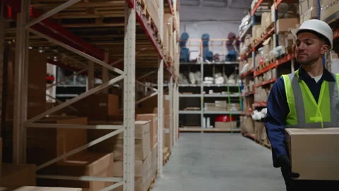 Warehouse Worker Placing a Box on Shelf Stock Footage 294265415
