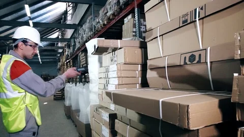 A warehouse worker in protective equipment uses a bar code scanner Video stock 88449400