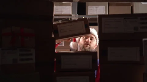 Warehouse worker puts cardboard box shelves full of cardboard boxes and parcels Stock Footage 247994145