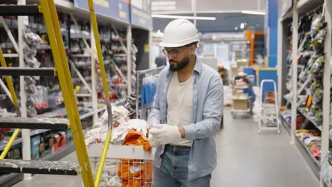 Warehouse worker putting on gloves before climbing ladder Stock-Footage 336965355