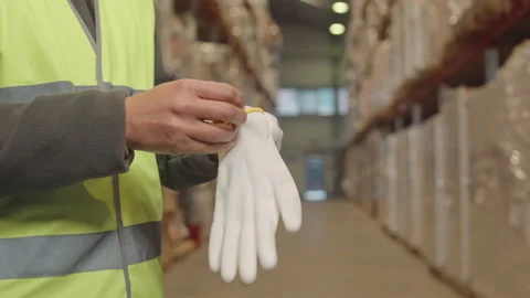 Warehouse Worker Putting on Gloves before Loading Parcels Stock Footage 242615432