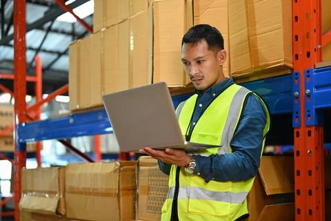 Warehouse worker in reflective jackets using digital tablet, checking stock and 스톡 사진