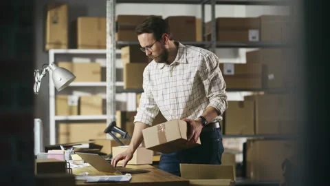Warehouse Worker Registering Parcel Using Laptop Stock Footage 218370771