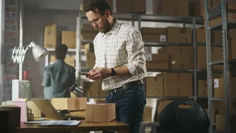 Warehouse Worker Registering Parcel Using Laptop Stock Footage 218419648
