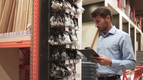 Warehouse worker scan goods in inventory in a hardware store and check stock Stock Footage 321613855