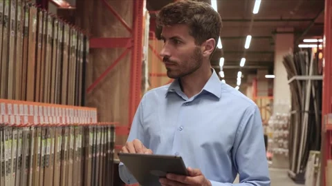 Warehouse worker scan goods in inventory in a hardware store and check stock Stock Footage 321613869