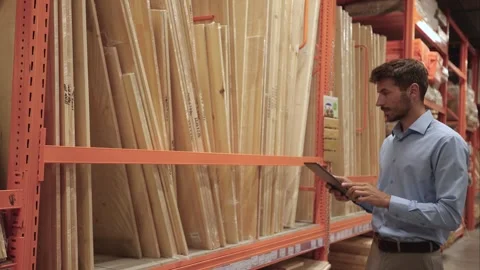 Warehouse worker scan goods in inventory in a hardware store and check stock Stock Footage 321613895