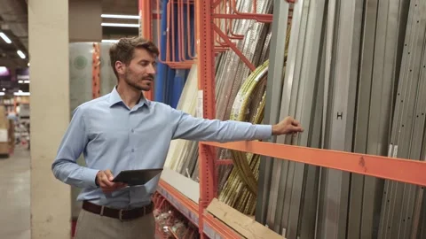 Warehouse worker scan goods in inventory in a hardware store and check stock Stock Footage 321613904