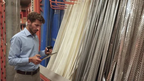 Warehouse worker scan goods in inventory in a hardware store and check stock Stock Footage 321613906